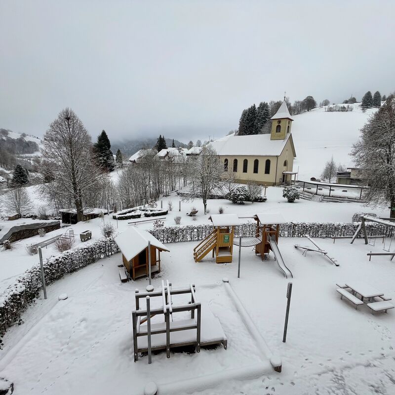 Schulhof im Schnee mit Kirche im Hintergrund - Schwarzwald